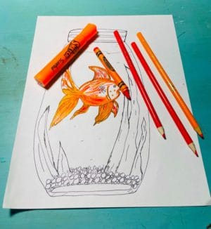 Coloring the fish orange with orange marker, crayon, and pencils.