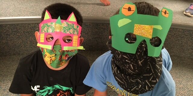 Two young people with colorful handmade paper masks!